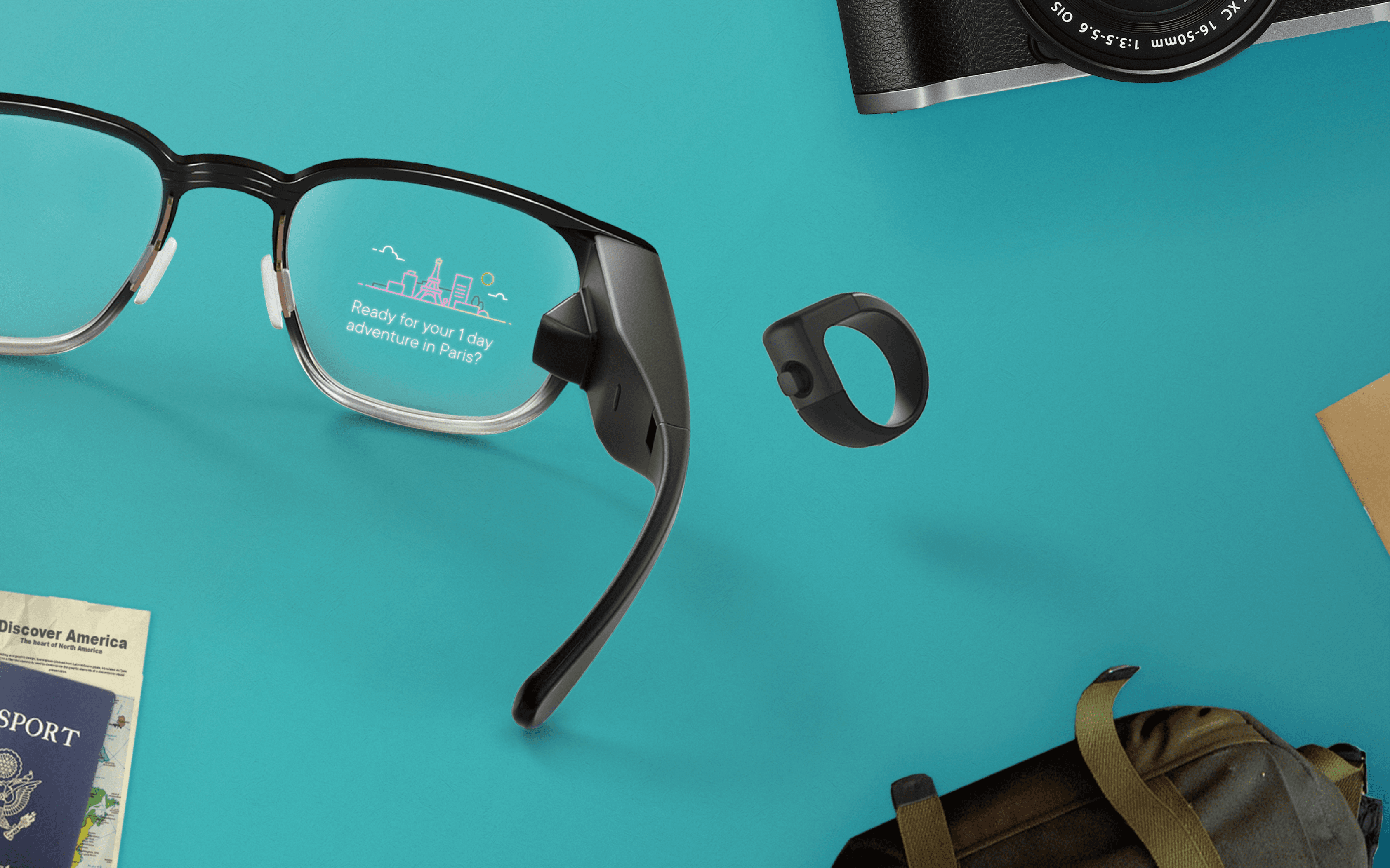 A pair of North AR smart glasses surrounded by a passport, backpack, camera, and ring.
